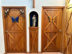 zwei Holztüren mit Schmetterlingen auf ihnen in einem Raum in der Unterkunft Quinta Las Victorias in El Valle de Antón