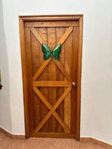 eine Holztür mit einem Schmetterling darauf in der Unterkunft Quinta Las Victorias in El Valle de Antón