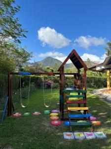 a playground with a slide and swings in a yard at Quinta Las Victorias in Valle de Anton