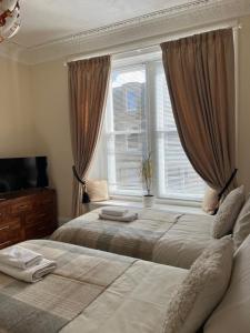 a bedroom with two beds and a window at Acorn House Callander in Callander