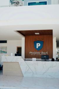 a lobby with a sign on a wooden wall at Hotel Presidente Beach Playas in Playas