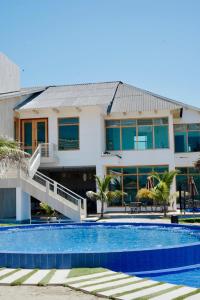 a house with a swimming pool in front of a building at Hotel Presidente Beach Playas in Playas