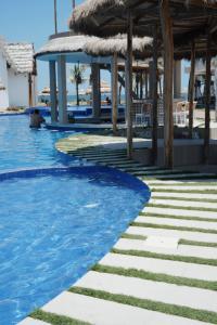 a swimming pool at a resort with chairs and tables at Hotel Presidente Beach Playas in Playas