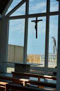 een kruis hangend aan een raam in een kerk bij President Beach Hotel & Eventos in Playas