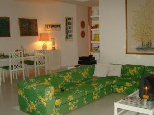 uma sala de estar com um sofá verde e uma mesa em O’Sole em Capri