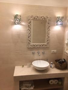 uma casa de banho com um lavatório e um espelho na parede em O’Sole em Capri
