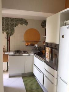 Una cocina con gabinetes blancos y un refrigerador. en O’Sole, en Capri