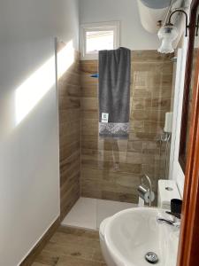 a bathroom with a sink and a shower with a towel at Alojamientos Capri in Quesada