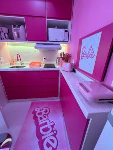 une cuisine rose avec un panneau barbier sur le comptoir dans l'établissement Barbie House POA, à Porto Alegre
