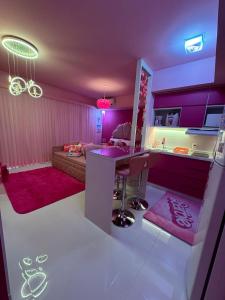 une cuisine aux murs violets et un salon avec un canapé dans l'établissement Barbie House POA, à Porto Alegre