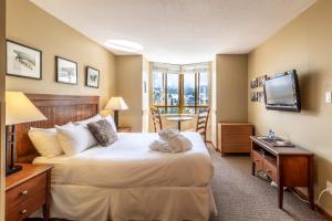 a hotel room with a bed and a television at Cascade by Elevate Vacations in Whistler