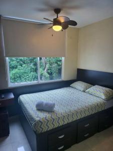 a bedroom with a bed with a ceiling fan and a window at R.7-7 Lindo estudio de 2 recámaras, zona turística in Panama City