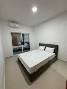 1 dormitorio con 1 cama blanca grande y ventana en BemVinda Sweet Home - Cama Mesa e Fogão en Praia