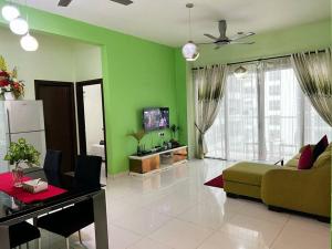 a living room with green walls and a couch at Cozy 2BR*Infinity Pool @ Regalia by baitul sakinah in Kuala Lumpur