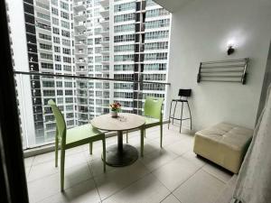 a living room with a table and chairs and a large window at Cozy 2BR*Infinity Pool @ Regalia by baitul sakinah in Kuala Lumpur