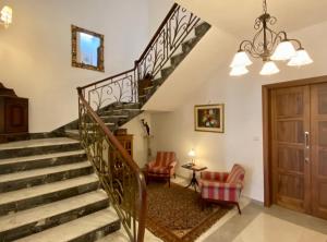 eine Treppe in einem Wohnzimmer mit 2 Stühlen in der Unterkunft Maltese Garden Villa in Mosta