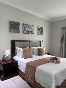 um quarto com uma cama grande e pinturas na parede em The Pillows Suite em Pretoria