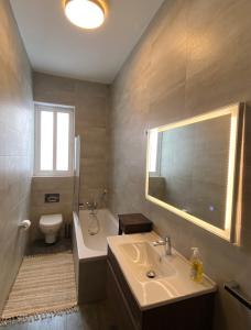 a bathroom with a sink and a tub and a toilet at Maltese Garden Villa in Mosta