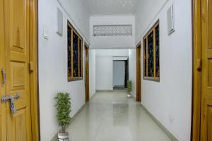 an empty hallway with a door and potted plants at OYO Hotel Triveni. in Patna