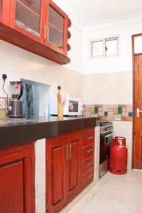 een keuken met houten kasten en een aanrecht bij Tollo 1br Utange Bamburi in Mombasa