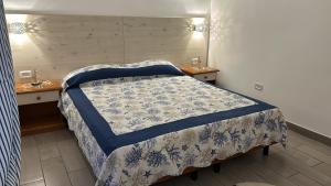 a bedroom with a bed with a blue and white quilt at Lilli's House in Gallipoli