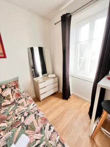 1 dormitorio con cama, tocador y espejo en LE PTIT STEIR - CALME - WIFI - CENTRE VILLE - ENTREE AUTONOME en Quimper