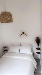 Little house (near Paris & Airport) في درانسي: سرير أبيض مع وسائد بيضاء وسقف