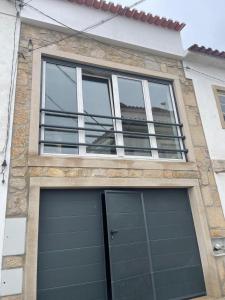 a house with two garage doors and windows at 3 Marias da Retirada in Lousa