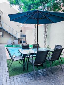 a table and chairs with an umbrella next to a pool at The Pillows Suite in Pretoria