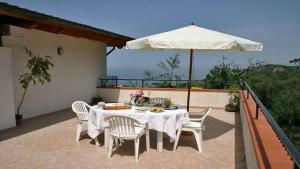 een tafel met stoelen en een parasol op een patio bij Studio für 4 Personen und 2 Kinder in Massa Lubrense, Kapanien Provinz Neapel in Massa Lubrense
