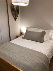 a bedroom with a white bed with a pillow at La Clusaz Escape in Manigod +20 photos