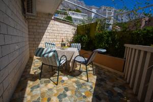 a table and chairs sitting on a patio at Apartmani Putnik in Baška Voda