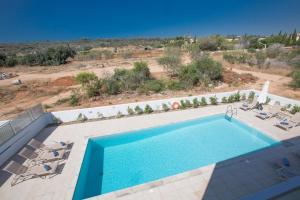 einen Blick über einen Pool mit Liegestühlen und Pool in der Unterkunft Ferienhaus für 10 Personen in Protaras, Südküste von Zypern - b59033 in Protaras