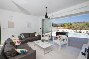 ein Wohnzimmer mit einem Sofa und einem Pool in der Unterkunft Ferienhaus für 10 Personen in Protaras, Südküste von Zypern - b59033 in Protaras