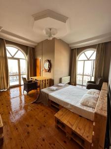 1 dormitorio con 1 cama, 1 mesa y 2 ventanas en Red Roof Seaview Hotel, en Baku
