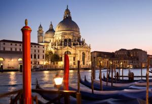 a group of gondolas in the water in front of a building at Messner Palace in Venice