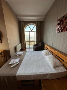 Red Roof Seaview Hotel في باكو: سرير كبير في غرفة مع نافذة كبيرة