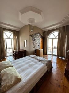ein Schlafzimmer mit einem großen Bett in einem Zimmer mit Fenstern in der Unterkunft Red Roof Seaview Hotel in Baku