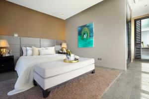 a bedroom with a white bed and a table at Villa Balimu Seminyak in Seminyak