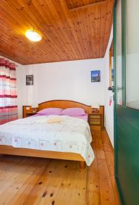 1 dormitorio con cama y techo de madera en Stone House Moj Dida en Živogošće