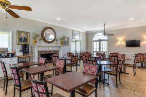 uma sala de jantar com mesas e cadeiras e uma lareira em Best Western PLUS Santee Inn em Santee