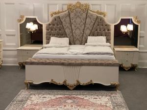 a bedroom with a king sized bed with a fancy headboard at Grand Station - Restaurang & Rooms in Oskarshamn