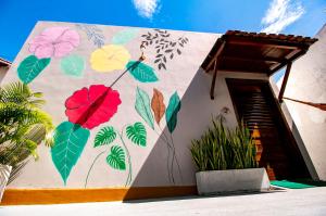 a building with a mural of flowers and leaves at Flat Tropical Caribessa in João Pessoa