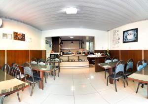 comedor con mesas y sillas y cocina en Guest House Mel & Mar, en Penha