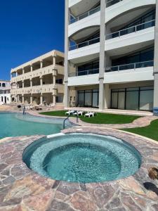 a swimming pool in front of a building at Palacio Del Mar - Oceanfront in Puerto Peñasco