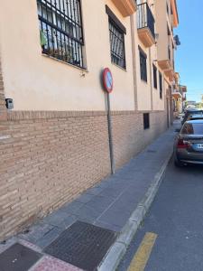 un letrero de la calle en una acera al lado de un edificio en Bonito piso a solo 15 minutos de Granada en La Zubia