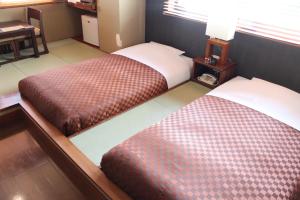 Postel nebo postele na pokoji v ubytování Hotel Saika