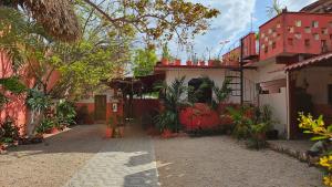 un patio de una casa con árboles y edificios en Casa Coral en Bacalar