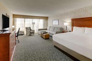 a hotel room with a large bed and a couch at Drury Inn & Suites Marion in Marion