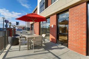 een tafel en stoelen met een rode parasol op een patio bij Drury Inn & Suites Marion in Marion